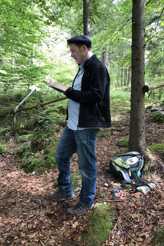 Oliver Pötzsch stands in the forest at the Döttenbichl and reads from his book The Play of Death