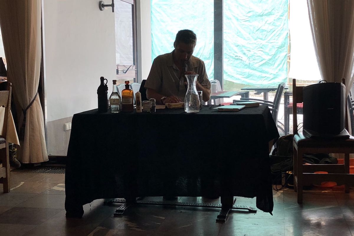 Oliver Pötzsch sits at a table and reads from his book The Play of Death